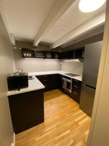 a kitchen with black cabinets and a wooden floor at Dronningens Gate 95, 0402 Kristiansand in Kristiansand