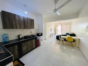 a kitchen and living room with a table and yellow chairs at 2 bedroom apt 323 Kisimani Heights, Mombasa, Kisimani in Mombasa