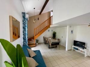 un soggiorno con un divano blu e un tavolo di BnGo I Maison Mimosa I Jardin, 3 chambres, 9 personnes a Villeurbanne