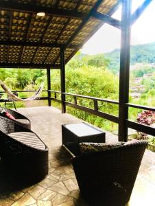 a patio with chairs and tables and a view of a mountain at Casa Monte Verde in Petrópolis
