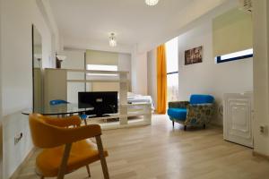 a living room with a table and chairs and a bed at Iassium Residence Iasi in Iaşi