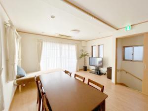 a living room with a dining room table and a tv at Dryokan Kumanocho in Tokyo