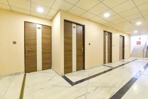 a row of elevators in a building with wooden doors at FabHotel Pearl Square in Jaipur