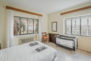 a bedroom with a bed and a chair and windows at La Casa de Arroyo in Arroyo de Cuéllar +28 photos