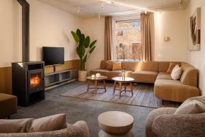 a living room with a couch and a fireplace at Dormio Resort Maastricht in Maastricht