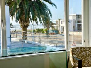 Habitación con vistas a una palmera y al océano en Central Seaview Villa Swakopmund, en Swakopmund
