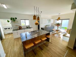cocina y comedor con una gran isla con taburetes en Central Seaview Villa Swakopmund, en Swakopmund