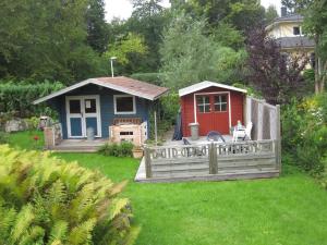 ein kleines Haus mit einem Zaun und einem Hof in der Unterkunft Privatvermietung Giese in Kiel