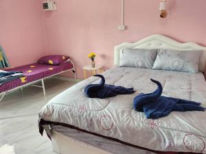 a bedroom with two blue towels on a bed at Suansubtawee Resort in Ban Baketa +15 photos