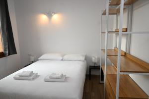 a bedroom with a white bed and a staircase at Homenfun Dalt Badalona in Badalona