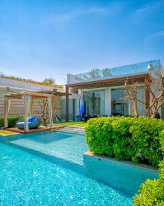 a house with a swimming pool in front of a house at A Dream Hua Hin - Beachfront Retreat in HHQ