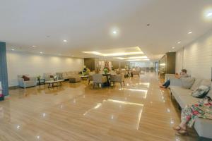 eine Lobby mit Leuten, die auf Sofas und Tischen sitzen in der Unterkunft Dreamy One bedroom Cozy Lush Family condo Air Gym Swim Park in Manila
