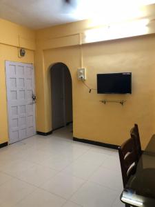 a room with a flat screen tv on a wall at Down Town Home Stay in Alibaug +4 photos
