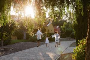a family walking down a path in a garden at ReBi Village in Imperia