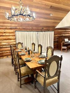 ein Esszimmer mit einem Tisch mit Stühlen und einem Kronleuchter in der Unterkunft Large Ski Club Style Lodge, Views, Walk to town in Wanaka