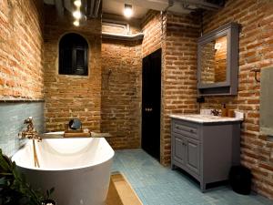 a bathroom with a large tub and a sink at Cataleya Estate Boutique Bed & Breakfast in Bangkok