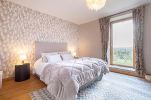 a bedroom with a bed and a large window at Les logis de Kergoulou in Concarneau