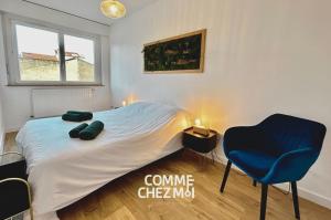 a bedroom with a bed and a blue chair at Appartement Nancy Thermal 6 personnes avec Garage in Nancy