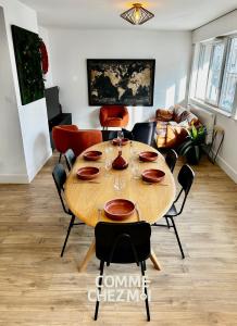 a dining room with a wooden table and chairs at Appartement Nancy Thermal 6 personnes avec Garage in Nancy +2 photos