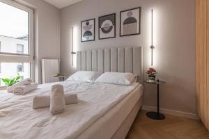 a bedroom with a large white bed with two pillows at River Side Residence in Oświęcim