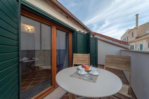 einen kleinen Balkon mit einem weißen Tisch und Stühlen in der Unterkunft Quentin's House in Alghero + 26 Fotos