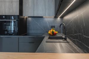 a kitchen with a sink with a bowl of fruit on it at River Side Residence in Oświęcim +48 photos