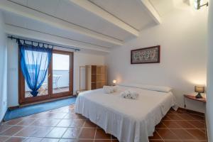 ein Schlafzimmer mit einem Bett und einem großen Fenster in der Unterkunft Quentin's House in Alghero