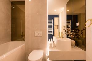 une salle de bains avec lavabo, baignoire et toilettes dans l'établissement Cortina North - Modern Studio Apartment with Balcony, à Voluntari