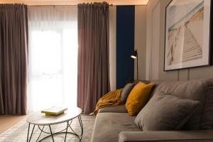 un salon avec un canapé et une table dans l'établissement Cortina North - Modern Studio Apartment with Balcony, à Voluntari 27 autres photos