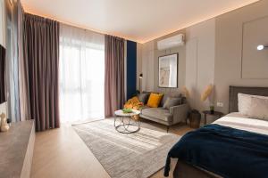 une chambre avec un lit et un salon avec un canapé dans l'établissement Cortina North - Modern Studio Apartment with Balcony, à Voluntari