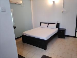 a bedroom with a bed with white sheets and two pillows at Akira Beach Hotel in Moratuwa