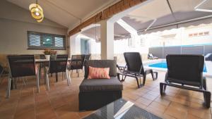ein Wohnzimmer mit einem Esstisch und Stühlen in der Unterkunft SeaHomes Vacations - Villa Chill & Pool 200m Beach in Pineda de Mar