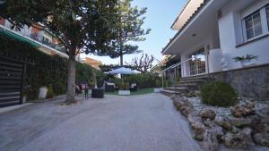 ein Haus mit einem Baum und einem Gebäude in der Unterkunft SeaHomes Vacations - Villa Chill & Pool 200m Beach in Pineda de Mar