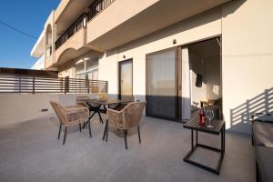 a patio with a table and chairs on a balcony at Beach Luxury Homes - Nicole in Lampi