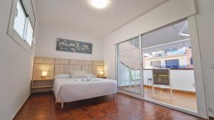 ein Schlafzimmer mit einem weißen Bett und einem großen Fenster in der Unterkunft SeaHomes Vacations - Villa Chill & Pool 200m Beach in Pineda de Mar + 43 Fotos