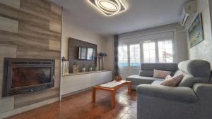 ein Wohnzimmer mit Couch und Kamin in der Unterkunft SeaHomes Vacations - Villa Chill & Pool 200m Beach in Pineda de Mar