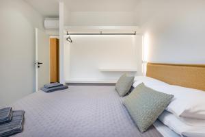 a bedroom with a large bed with two pillows at Beach Luxury Homes - Nicole in Lampi