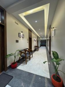 a hallway with two potted plants in a building at Hotel Sundarai Lodging in Jāmkhed
