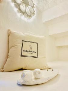 a pillow with a sign on it next to some candles at L’Edicola Votiva in Casarano