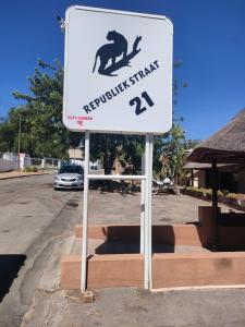 ein Schild auf einem Parkplatz mit einem Affen drauf in der Unterkunft Leopard Tree Guesthouse in Springbok