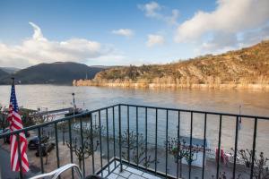 Ein Boot liegt an einem Fluss mit einer Flagge. in der Unterkunft Hotel Garni Günther in Boppard