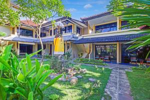 a house with a garden in front of it at Collection O Legian Near Bimc Hospital Nusa Uda Formerly Anna Kuta Inn in Legian