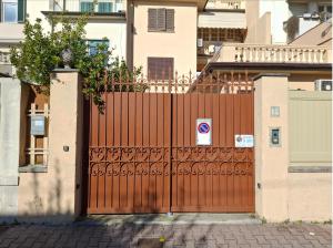 a red gate with a tree on top of it at Casachiara in Viareggio +3 photos