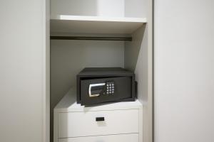 a microwave sitting on top of a white cabinet at La Corte Rental Room in Teramo