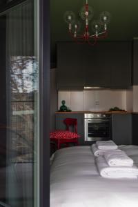a bedroom with a bed and a kitchen with black cabinets at Wolne Pokoje I Boutique Apartments in Wrocław