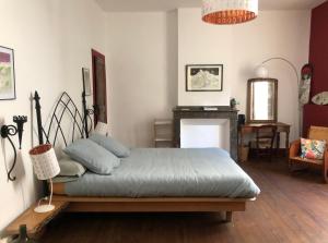 a bedroom with a bed and a living room with a fireplace at Les Trois Hiboux in Crespin