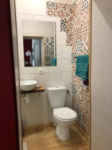 a bathroom with a toilet and a sink at Les Trois Hiboux in Crespin