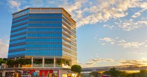a tall glass building with a sky at Savoy Hotel Manila near NAIA Terminal 3 MNL in Manila