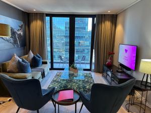 una sala de estar con un sofá y una mesa en Urban Elephant 16 On Bree, en Ciudad del Cabo