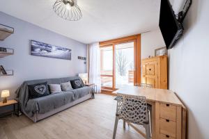 a living room with a couch and a table at Pierra Menta - Vue montagne station à pied in Peisey-Nancroix